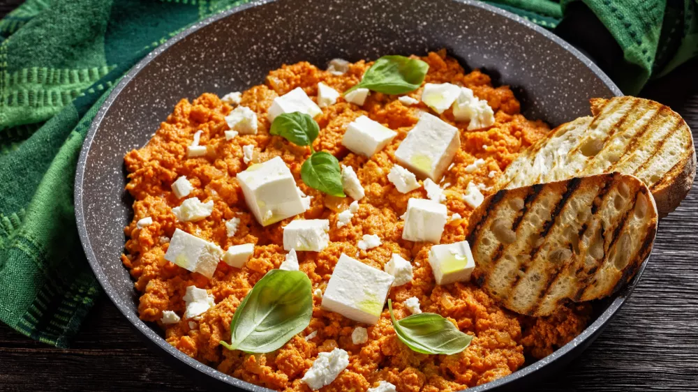 Strapatsada, eggs scrambled with tomatoes and feta cheese in a skillet with toasted bread, horizontal view, greek cuisine / Foto: From_my_point_of_view