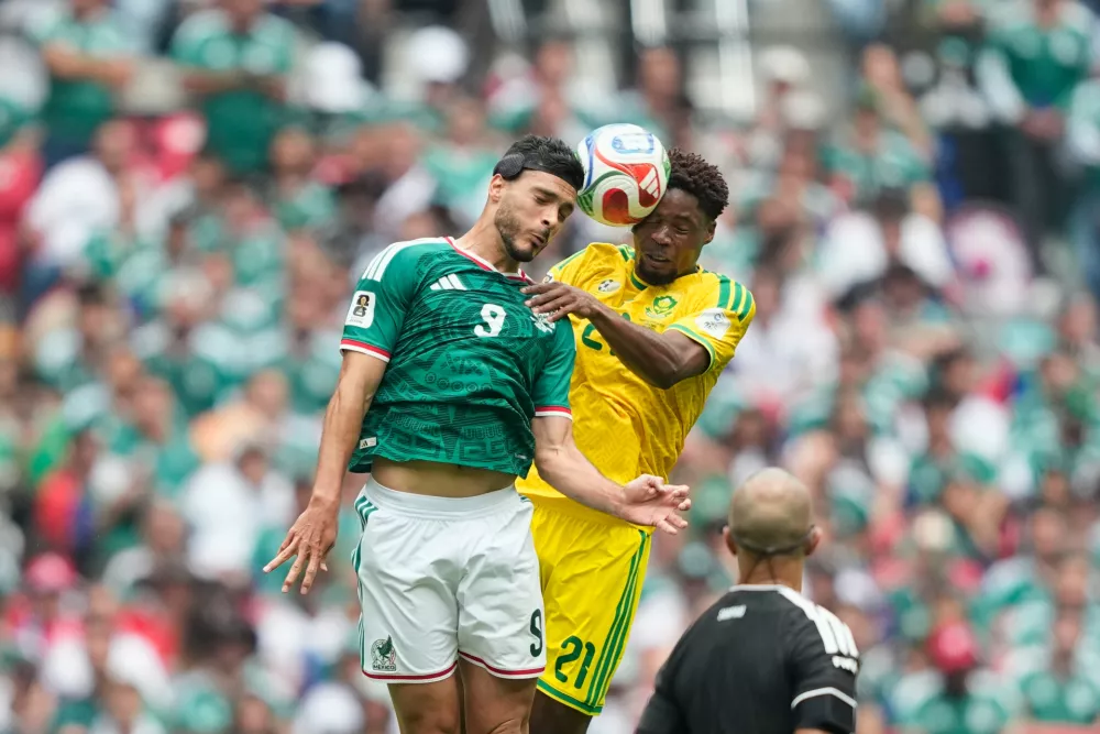 Mexico's Raul Jimenez, left, jumps for the ball with South Africa's Ime Okon during the World Cup Group A soccer match between Mexico and South Africa in Mexico City, Thursday, June 11, 2026. (AP Photo/Natacha Pisarenko)