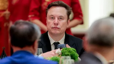FILE PHOTO: Tesla CEO Elon Musk holds a mobile phone as he arrives to attend a state banquet with U.S. President Donald Trump and Chinese President Xi Jinping at the Great Hall of the People in Beijing, China, May 14, 2026. REUTERS/Evan Vucci//File Photo