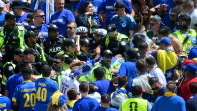 Toronto Police officers interact with Bosnia fans in the stands before the World Cup Group B soccer match between Canada and Bosnia, Friday, June 12, 2026, in Toronto. (Sammy Kogan/The Canadian Press via AP)