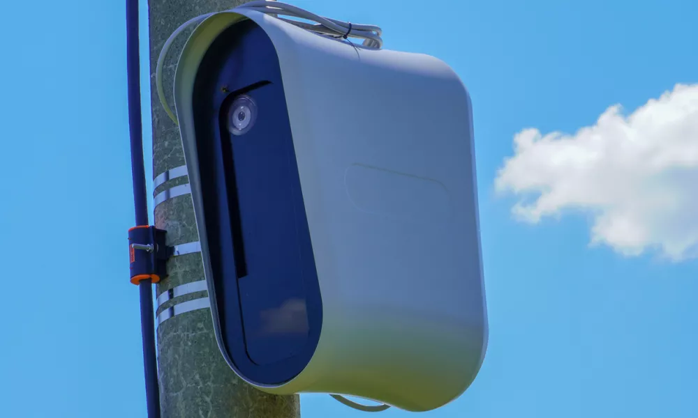 Closeup of a modern speed camera (traffic speed monitoring camera) against a clear blue sky