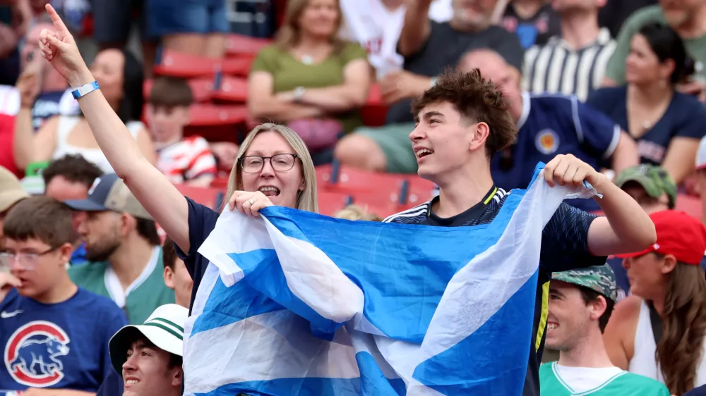 Fans of the Scotland men's soccer team sing and dance before a baseball game between the Boston Red Sox and the Texas Rangers, Sunday, June 14, 2026, in Boston. (AP Photo/Mark Stockwell)