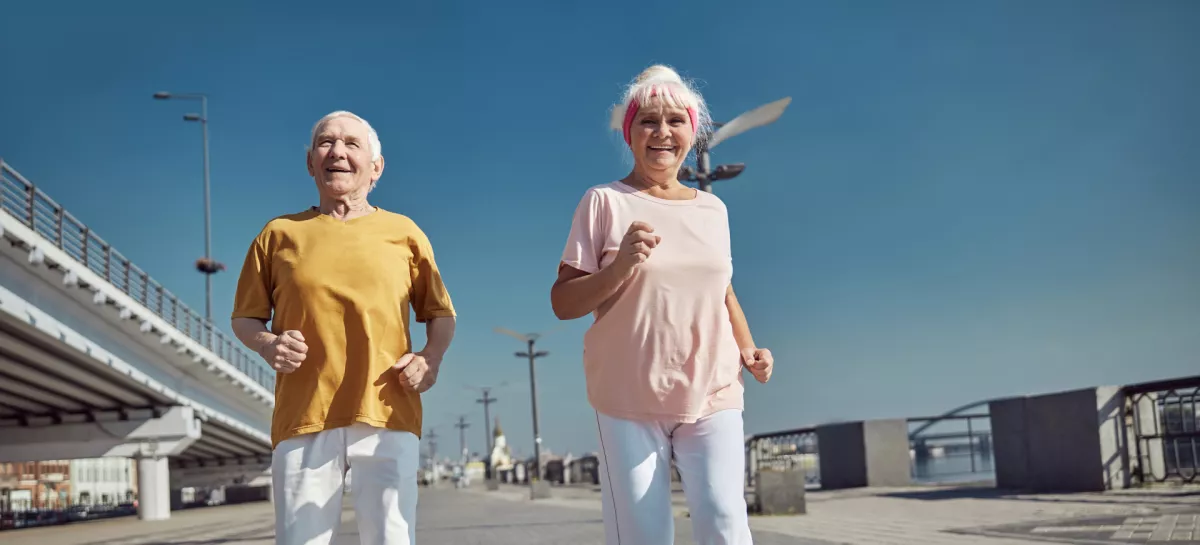 Full-length portrait of a high-spirited senior lady and her husband power walking along the quay / Foto: Yacobchuk