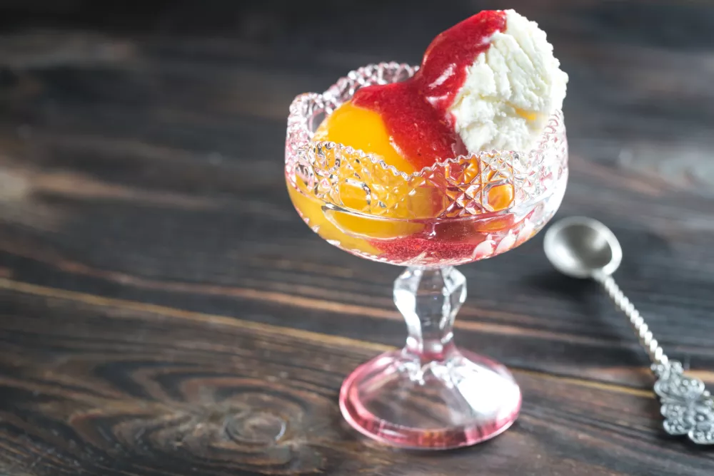Bowl of Peach Melba - vanilla ice cream with peaches and raspberry sauce / Foto: Alexpro9500