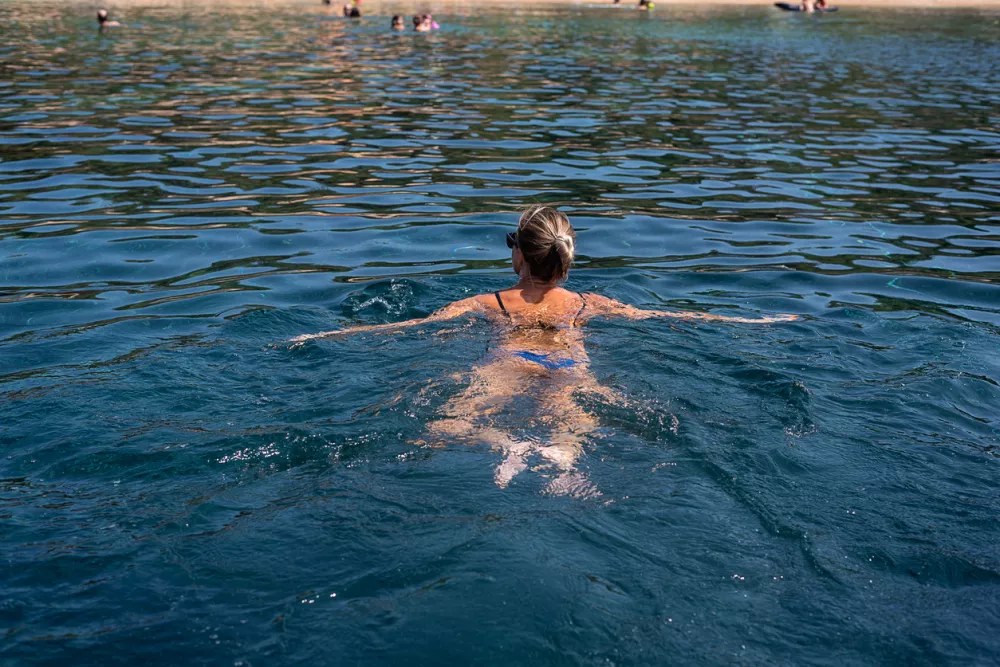 Back view at woman swimming in sea. Middle aged woman enjoying summer holidays / Foto: Anna Gorbacheva