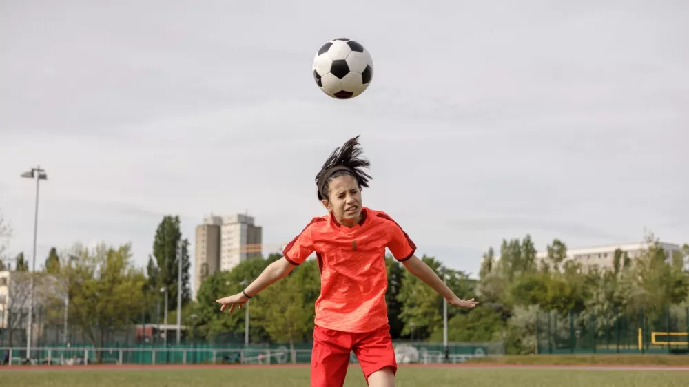 A girl soccer player heading the ball / Foto: Istock
