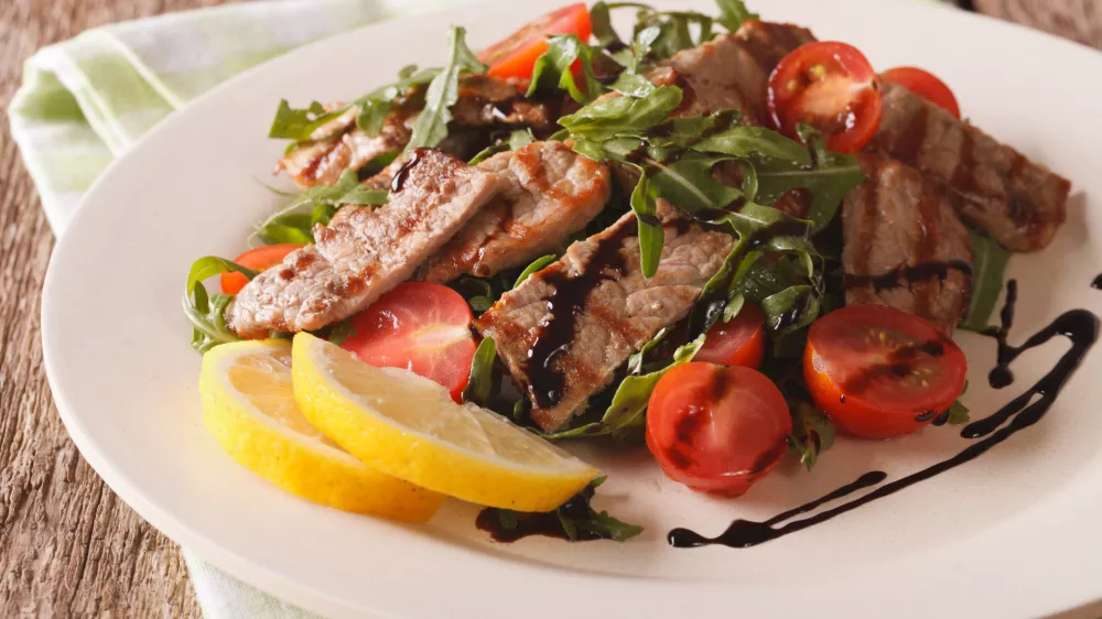 Straccetti&nbsp;salad with grilled beef, arugula and tomatoes close-up on the table. Horizontal / Foto: Alleko