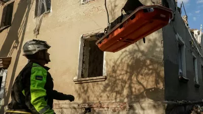 Rescuers use a crane to carry the bodies of people found under debris of an apartment building which was hit by a Russian air strike, amid Russia's attack on Ukraine, in Kharkiv, Ukraine June 20, 2026. REUTERS/Sofiia Gatilova