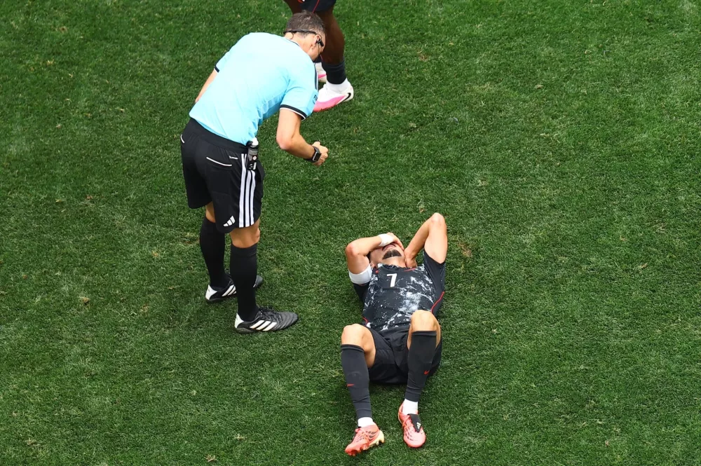 Soccer Football - FIFA World Cup 2026 - Round of 32 - South Africa v Canada - Los Angeles Stadium, Inglewood, California, U.S. - June 28, 2026 Canada's Stephen Eustaquio is checked on by referee Joao Pedro Pinheiro after sustaining an injury REUTERS/Lisi Niesner / Foto: Lisi Niesner