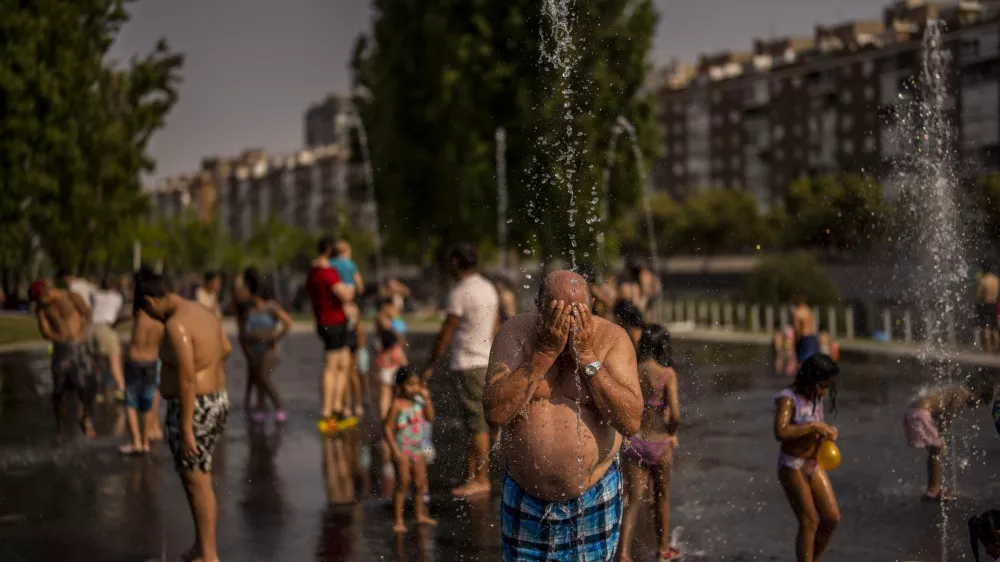 People cool off in an urban beach at Madrid Rio park in Madrid, Spain, Wednesday, July 13, 2022. Weather forecasters say Spain is expected to have its second heat wave in less than a month and that it will will last at least until the weekend. Meteorologists said an overheated mass of air and warm African winds are driving temperatures in the Iberian Peninsula beyond their usual highs. (AP Photo/Manu Fernandez)