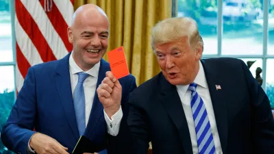 FILE - President Donald Trump holds up a red card during a meeting with FIFA president Gianni Infantino in the Oval Office of the White House, Tuesday, Aug. 28, 2018, in Washington. (AP Photo/Evan Vucci, File)