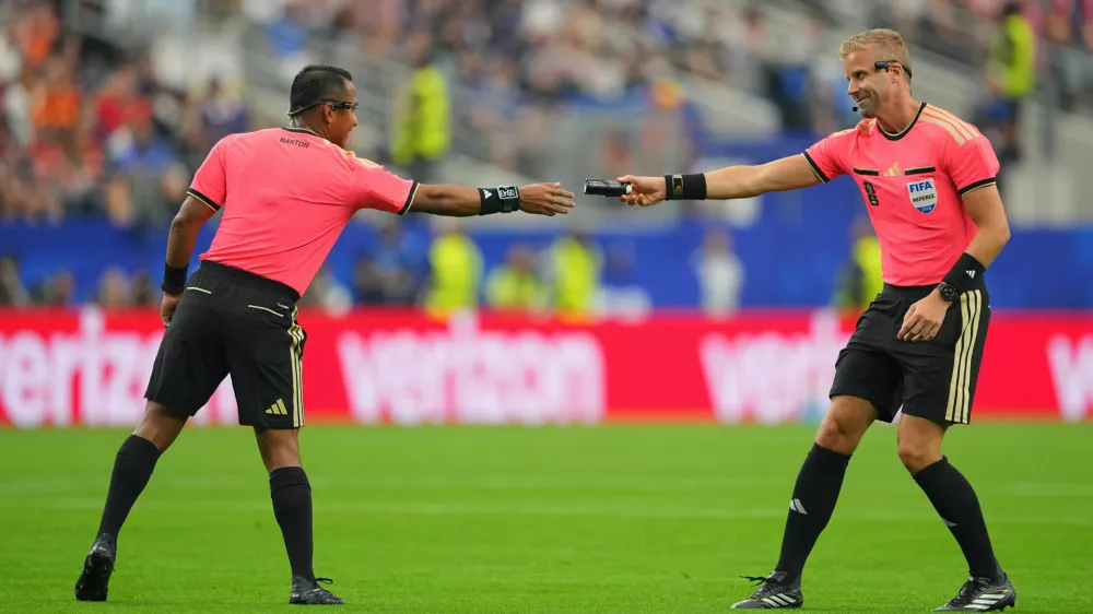 An assistant referee hands referee Ivan Barton of El Salvador the vanishing spray during a World Cup semifinal soccer match between France and Spain in Arlington, Texas, near Dallas, Tuesday, July 14, 2026. (AP Photo/Julio Cortez) / Foto: Julio Cortez