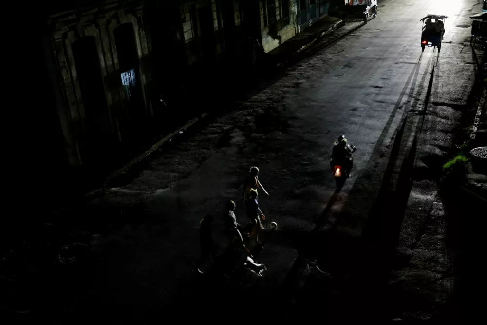 People cross a street as Cuba's national power grid collapsed, marking the third major outage in nine days, in Havana, Cuba, July 14, 2026. REUTERS/Norlys Perez