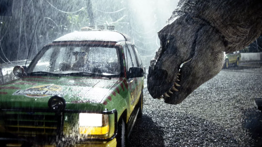 A tyrannosaurus rex terrorizes people trapped in a car in a scene from the 1993 American film Jurassic Park directed by Steven Spielberg. The sci-fi adventure stars Sam Neill, Laura Dern, and Jeff Goldblum. The film is an adaptation of Michael Crichton's novel of the same name. (Photo by Murray Close/Sygma/Sygma via Getty Images)