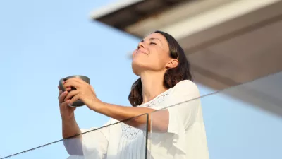 Adult woman with coffee cup breathing on a balcony / Foto: Pheelings Media Getty Images