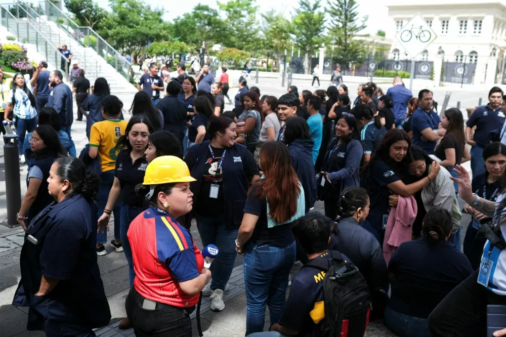 People stand outside the Biblioteca Nacional after evacuating the building following a powerful 7.4-magnitude earthquake that struck off the coast of Mexico's southern state of Chiapas, triggering a tsunami warning and shaking buildings in neighboring Guatemala and El Salvador, in San Salvador, El Salvador, July 17, 2026. REUTERS/Jose Cabezas