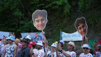Spectators wave pictures of France's Paul Seixas in the Alpe d'Huez during the nineteenth stage of the Tour de France cycling race with start in Gap and finish in Alpe d'Huez, France, Friday, July 24, 2026. (AP Photo/Mosa'ab Elshamy)