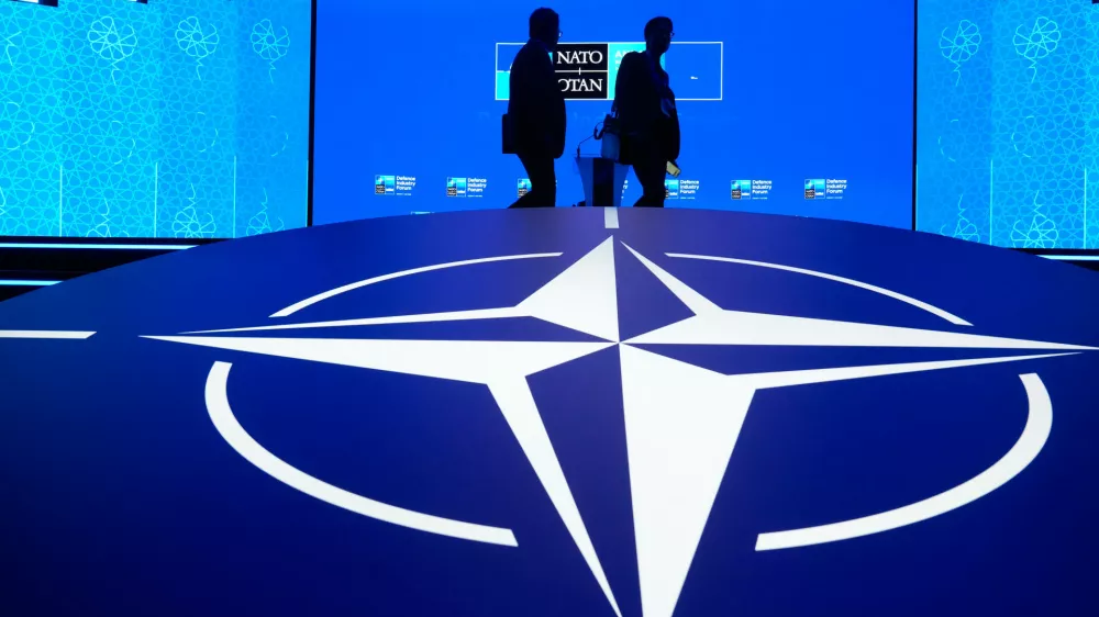Two men walk past the NATO logo during the NATO Defense Industry Forum at the NATO summit in Ankara, Turkey, Tuesday, July 7, 2026. (AP Photo/Hussein Malla) / Foto: Hussein Malla