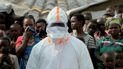 FILE PHOTO: A health worker in personal protective equipment stands near displaced people waiting for the burial of suspected Ebola victims at the Kigonze displaced persons camp, one month after an outbreak was declared, in Bunia, eastern Democratic Republic of Congo, June 18, 2026. REUTERS/Gradel Muyisa Mumbere/File Photo
