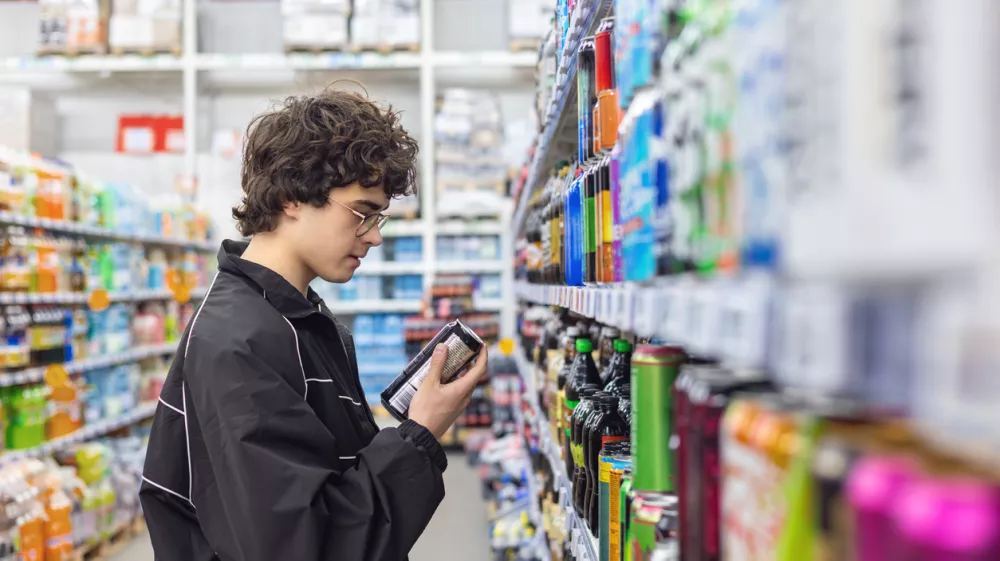 Adolsent boy reading beverage label while shopping in supermarket. unhealthy beverage habits and health risk / Foto: Svetlana Mishchenkogetty Images