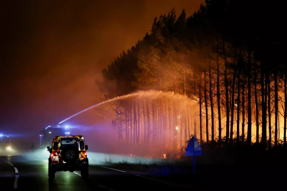 Firefighters work in Le Porge as a wildfire burns in a forest area in the Gironde department amid worsening drought conditions following a heatwave and water shortages across much of France, July 23, 2026. REUTERS/Stephane Mahe