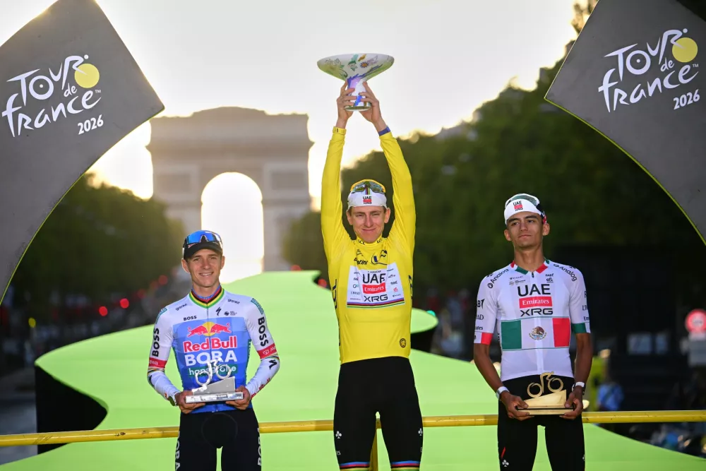 Slovenia's Tadej Pogacar, wearing the overall leader's yellow jersey, celebrates on the podium after winning the Tour de France cycling race alongside Belgium's Remco Evenepoel, second, and Mexico's Isaac Del Toro, third, in Paris, Sunday, July 26, 2026. (AP Photo/Bernard Papon/Pool Photo via AP) / Foto: Ap