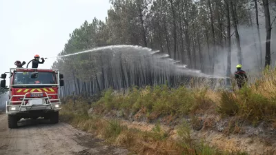 Firefighters suppress a blaze in a forest as wildfires rage near Le Las, outside Bordeaux, France, Monday, July 27, 2026. (AP Photo/Emma Da Silva)