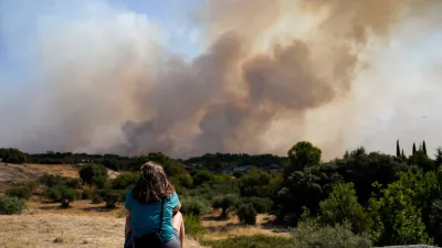 A woman looks as smoke rises from a wildfire in San Martin de Valdeiglesias, Community of Madrid, Spain, July 26, 2026. REUTERS/Ana Beltran  TPX IMAGES OF THE DAY