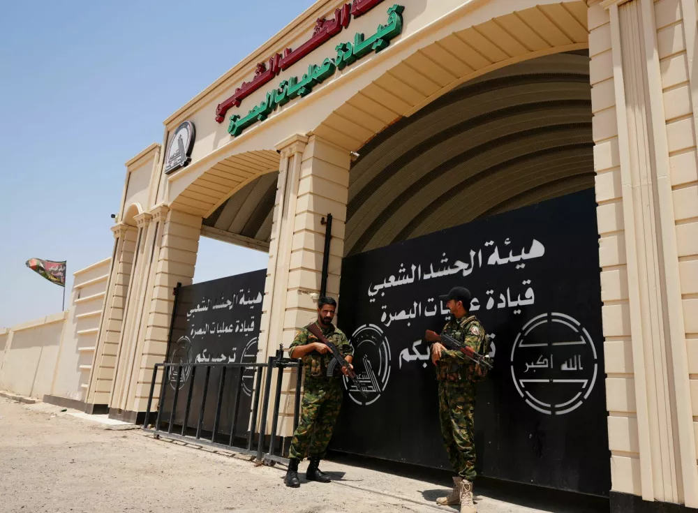 Members of Iraq's Popular Mobilization Forces (PMF) stand guard outside the Basra Operations Command headquarters, following airstrikes that the PMF said were carried out by U.S. and Saudi forces in Basra, Iraq July 29, 2026. REUTERS/Essam Al-Sudani