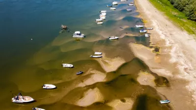 Boats sit on a bank of the Danube River where usually submerged areas are exposed due to extremely low water levels following an extended period of drought in Islaz, Romania, Wednesday, July 29, 2026. (AP Photo/Nicolae Dumitrache)