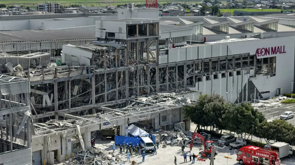 In this aerial image taken with a drone, responders work outside AEON Mall Kumamoto after an explosion occurred following an earthquake, in Kashima, Kumamoto Prefecture, southern Japan, Thursday, July 30, 2026. (Koji Harada/Kyodo News via AP)