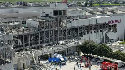 In this aerial image taken with a drone, responders work outside AEON Mall Kumamoto after an explosion occurred following an earthquake, in Kashima, Kumamoto Prefecture, southern Japan, Thursday, July 30, 2026. (Koji Harada/Kyodo News via AP)