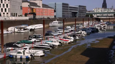 A man walks on a pier as boats lie in the partially dried-up Rheinauhafen harbour basin during low water levels on the Rhine river in Cologne, Germany, July 30, 2026. REUTERS/Thilo Schmuelgen / Foto: Thilo Schmuelgen