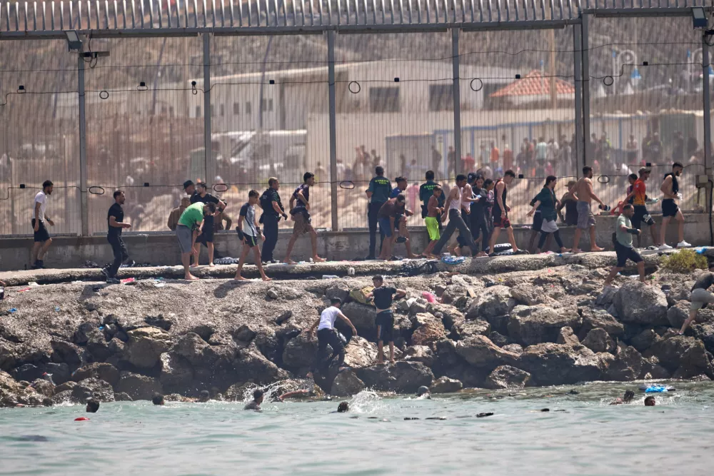 Migrants cross from Morocco into the Spanish enclave of Ceuta, Thursday, July 30, 2026. (AP Photo/Antonio Sempere)