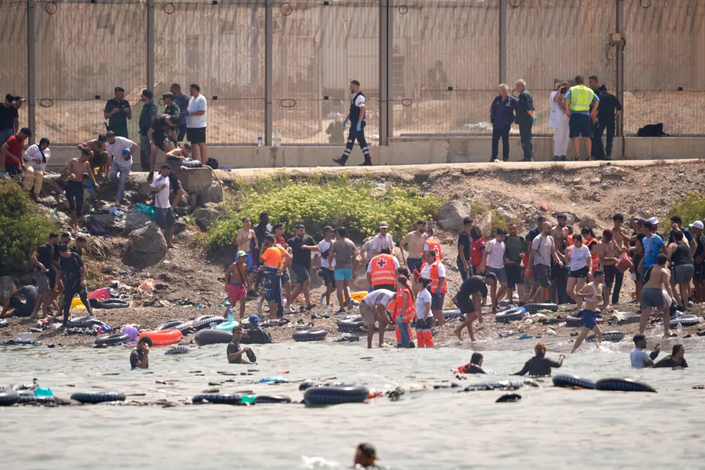 Migrants cross from Morocco into the Spanish enclave of Ceuta, Thursday, July 30, 2026. (AP Photo/Antonio Sempere)
