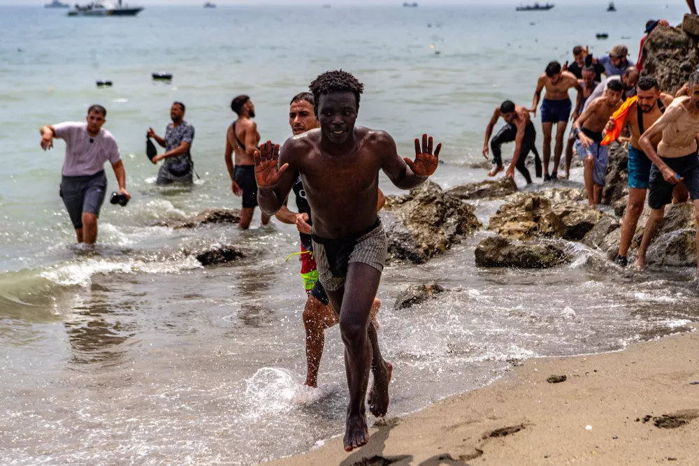Migrants cross from Morocco into the Spanish enclave of Ceuta, Thursday, July 30, 2026. (AP Photo/Antonio Sempere)