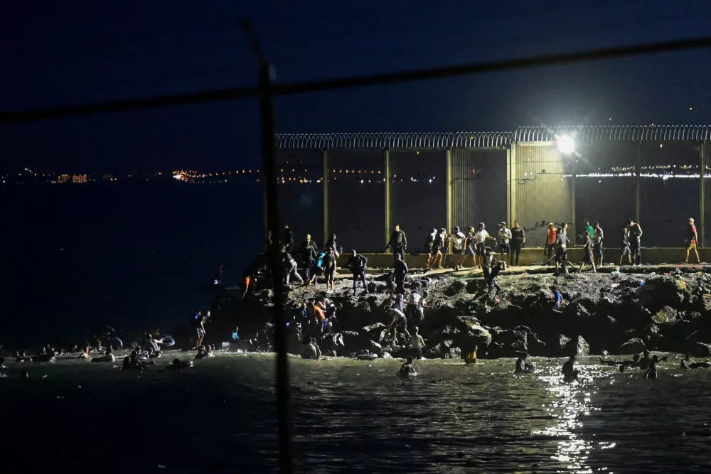 Migrants from Morocco cross into Ceuta by sea and gather near the border fence between the Spanish enclave of Ceuta and Morocco, as seen from Ceuta, Spain, July 30, 2026. REUTERS/Fabian Bimmer