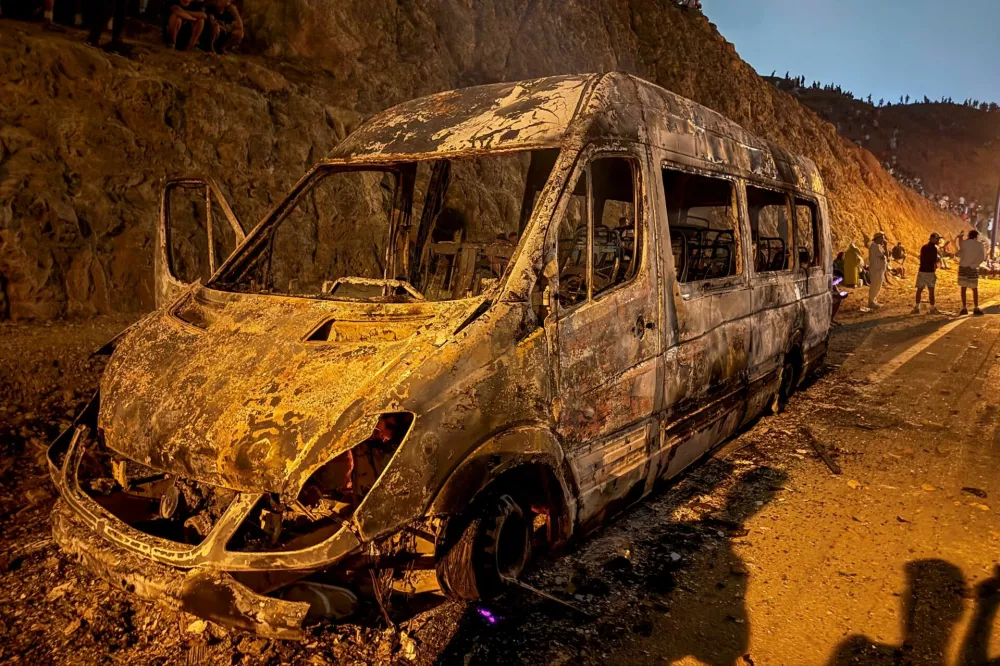 A burned vehicle as migrants wait for a chance to cross to the Spanish enclave of Ceuta, on the Moroccan side of the border in Fnideq, Morocco, July 31, 2026. Picture taken with a mobile phone. REUTERS/Stringer