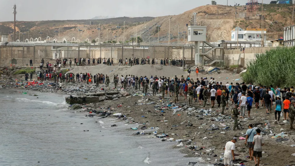 People walk towards the border with Morocco leaving Spain, amid mass crossings of migrants on foot and by sea from Morocco into Spanish territory, in Ceuta, Spain, July 31, 2026. REUTERS/Jon Nazca   TPX IMAGES OF THE DAY
