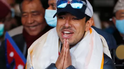 FILE - Nirmal Purja, one of the team member of the all-Nepalese mountaineering team that became the first to scale Mount K2 in winter, gestures as the team arrives at Tribhuwan International airport in Kathmandu, Nepal, Jan. 26, 2021. (AP Photo/Niranjan Shrestha, File)