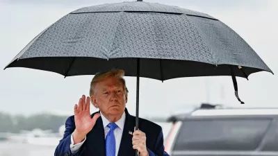 U.S. President Donald Trump gestures as he holds an umbrella after disembarking Air Force One at Joint Base Andrews, in Maryland, U.S., August 2, 2026. REUTERS/Daniel Heuer