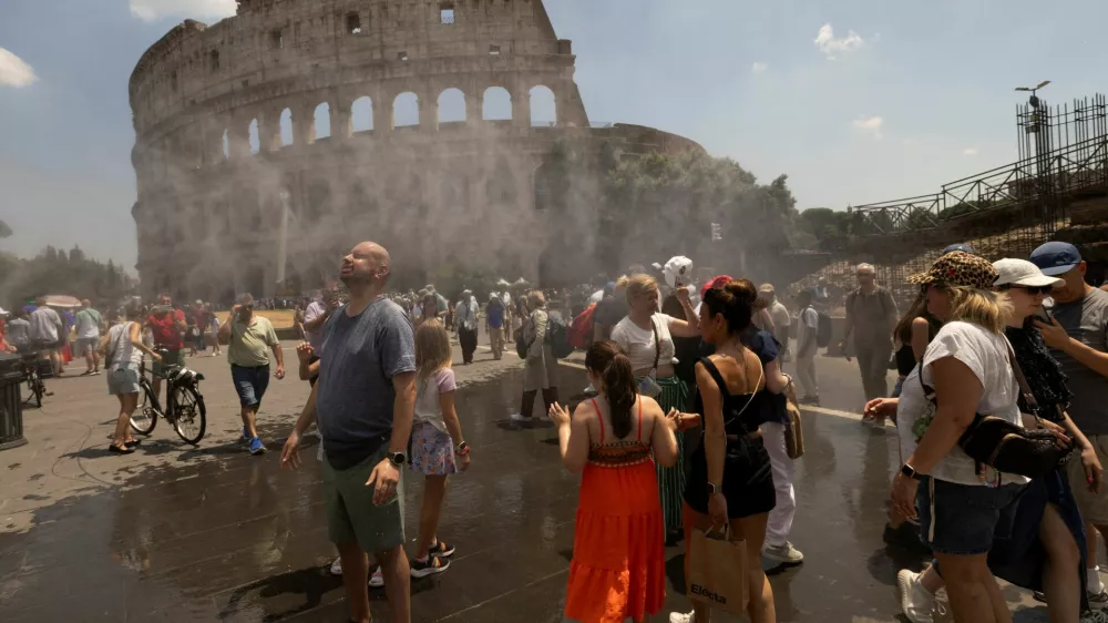 People cool off under a water mist near the Colosseum as Italy's Civil Protection deploys measures to help residents and tourists cope with a heatwave, in Rome, Italy, June 26, 2026. REUTERS/Remo Casilli