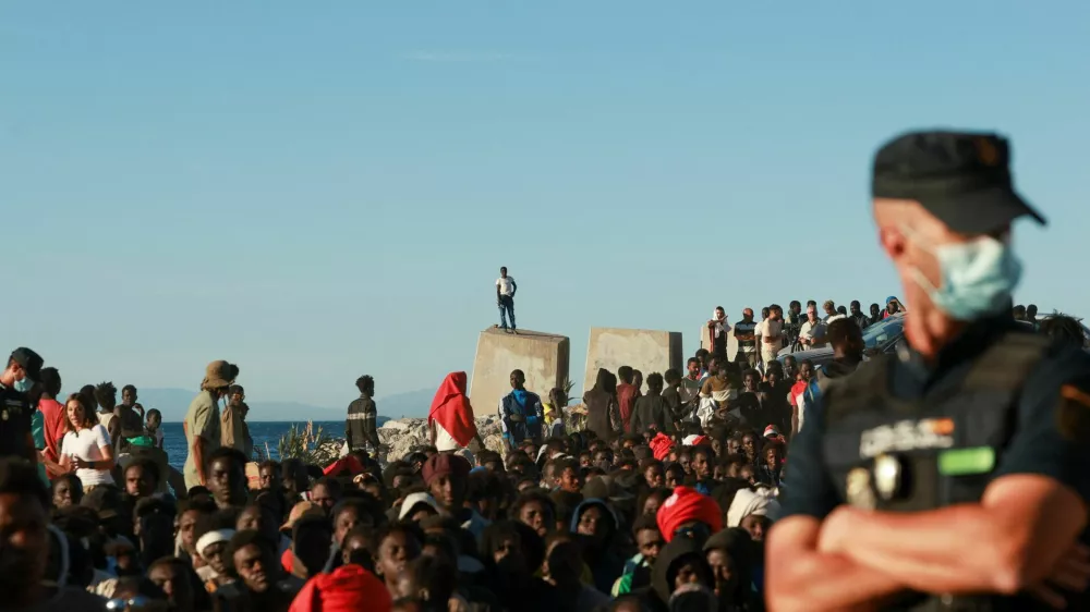 Migrants wait in line to receive food and beverage from the Red Cross, following mass crossings of migrants on foot and by sea from Morocco into Spanish territory, in Ceuta, Spain, August 3, 2026. REUTERS/Violeta Santos Moura