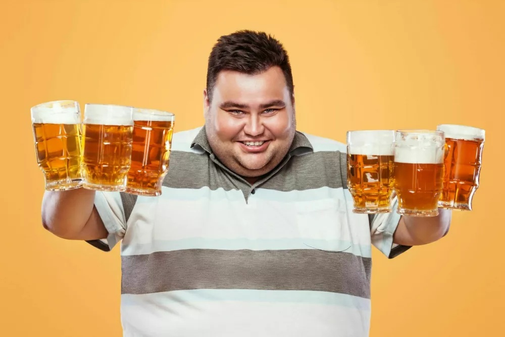 Half-length portrait of young fat man with holding the beer mug Isolated on solid background / Foto: Mikeorlov