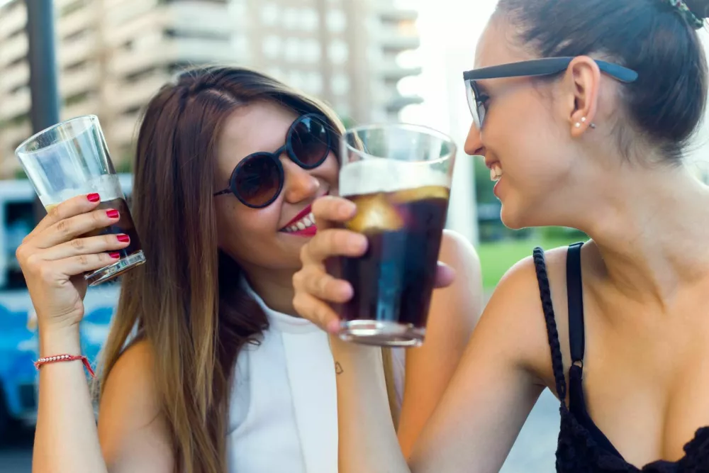 Portrait of beautiful young women drinking refreshment in the street. / Foto: Nensuria