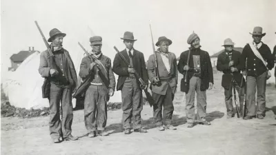 Oboroženi stavkajoči v &scaron;otorskem naselju Ludlow leta 1914. Na fotografiji je mogoče videti bele &scaron;otore, ki jih je zagotovil sindikat United Mine Workers of America, ter pu&scaron;ke z vzvodnim mehanizmom, ki so bile raz&scaron;irjene na obeh straneh spopada. / Foto: Wikipedija