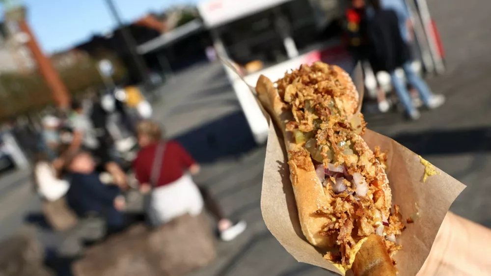 A tourist holds up a hotdog ordered from one of the classic fast food stands in central Copenhagen, Denmark, July 23, 2026. REUTERS/Tom Little