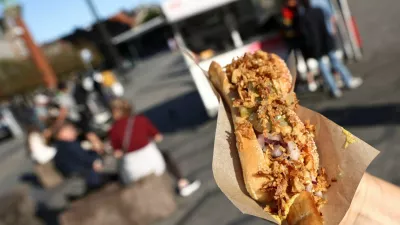 A tourist holds up a hotdog ordered from one of the classic fast food stands in central Copenhagen, Denmark, July 23, 2026. REUTERS/Tom Little