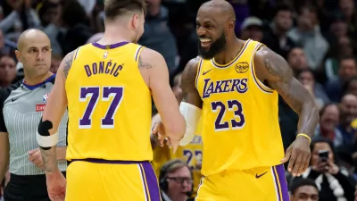 Los Angeles Lakers forward/guard Luka Dončić (77) celebrates a three point basket with forward LeBron James (23) against the New Orleans Pelicans during the second half of an NBA basketball game in New Orleans, Tuesday, Jan. 6, 2026. (AP Photo/Matthew Hinton)