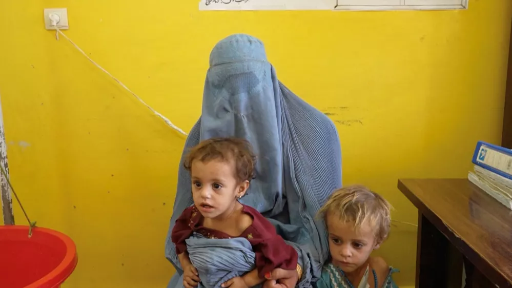 Sadiqa, 30, from Helmand, speaks while with two of her daughters, Sofia and Nazdana, who are suffering from malnutrition, at a clinic in Helmand, Afghanistan, July 14, 2026, in this still image taken from a handout video. WFP/Handout via REUTERS THIS IMAGE HAS BEEN SUPPLIED BY A THIRD PARTY. MANDATORY CREDIT.
